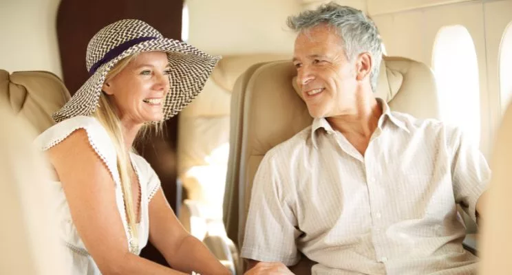 Smiling couple in their 60s talking in the cabin of a private jet